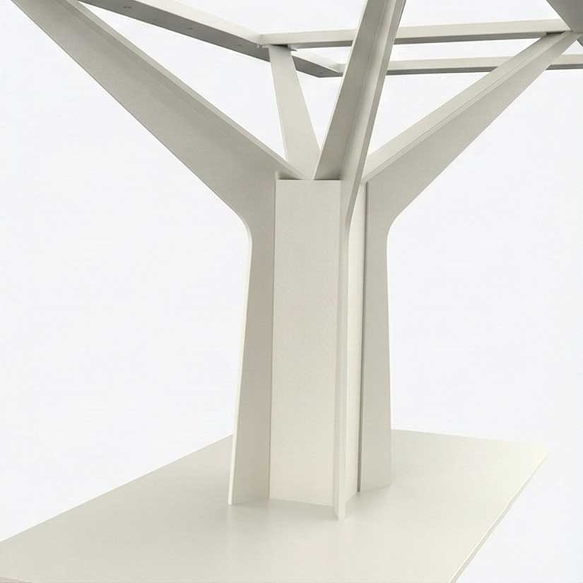 Close-up of a white metal table leg with angled Y-shaped supports converging at a central column on a white surface.